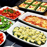 **Image:** A vibrant and colorful low-carb buffet at a German Christmas party. Guests are enjoying dishes like zucchini lasagna, cauliflower pizza, and salads with avocado oil dressing. Some have brought their own low-carb dishes to share. The atmosphere is festive and inclusive, showing how to enjoy social events while maintaining a low-carb lifestyle. Focus on showcasing healthy and delicious food options.